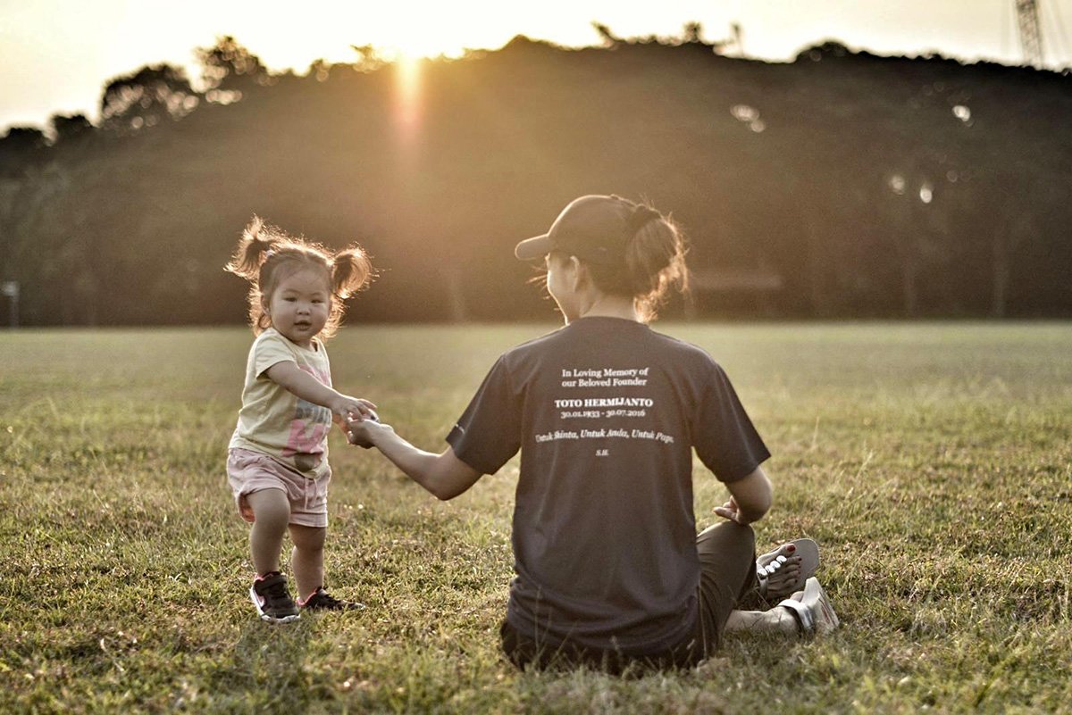 Stacey Hermijanto holding hands with her young daughter